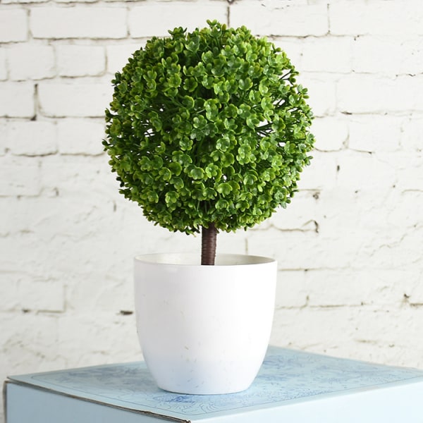 Små konstgjorda blomkrukor i form av en topiary, i vitt