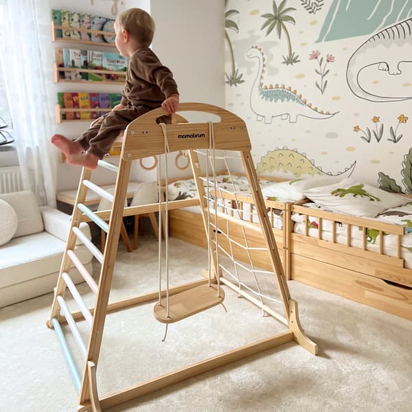 Inomhus lekplats i trä med gunga, ringar och klätternät