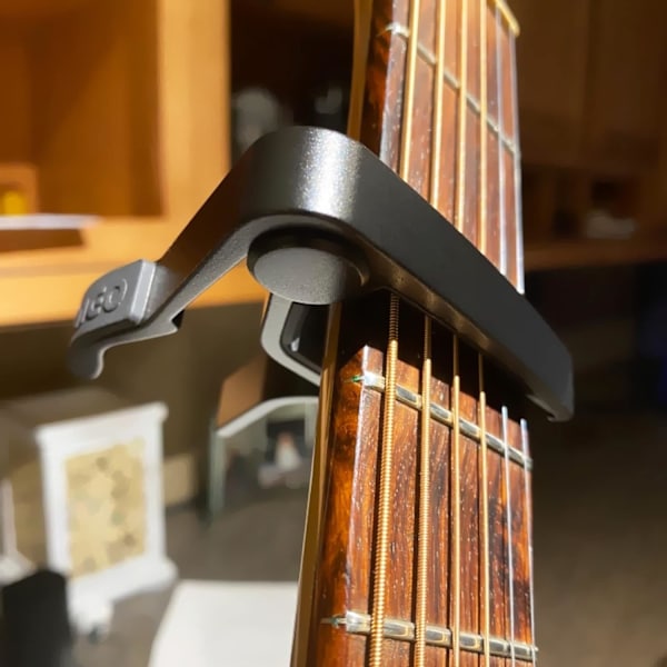 Gitarr Capo för akustiska och elektriska gitarrer med 5 plektrum gratis, svart