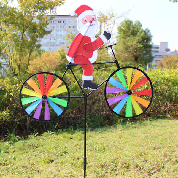3D Stor snögubbe Jultomten på cykel vindkraftverk vindsnurra snurrande trädgård