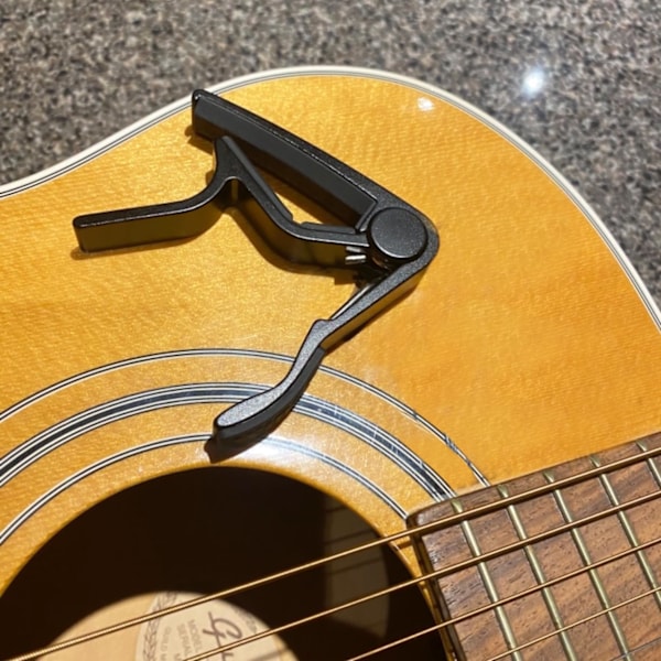 Gitar-kapo for akustiske og elektriske gitarer med 5 gratis plektrum, svart