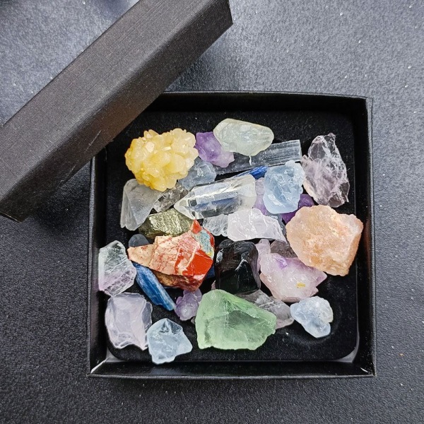 1 laatikko sekavärisiä mineraalinäytteitä luonnonkristallisista raakakivistä