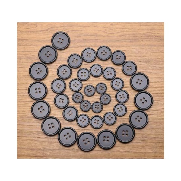100 isoa mustaa ompelunappia (25 mm)