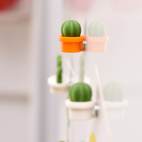 Et sett med 12 dekorative kjøleskapsmagneter, oransje og hvite, pe