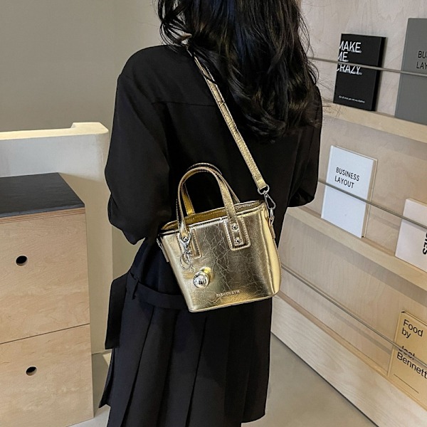 Sommar Populär All-Matching Handväskor Kvinnliga 2024 Ny Western Style All-Matching Axelväska Hög Sense Fashion Bucket Bag Golden Tape Pendant