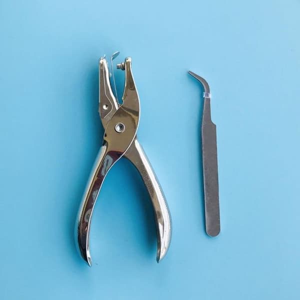 1 DIY-kit för bokmärken, inklusive hålslag och pincett.