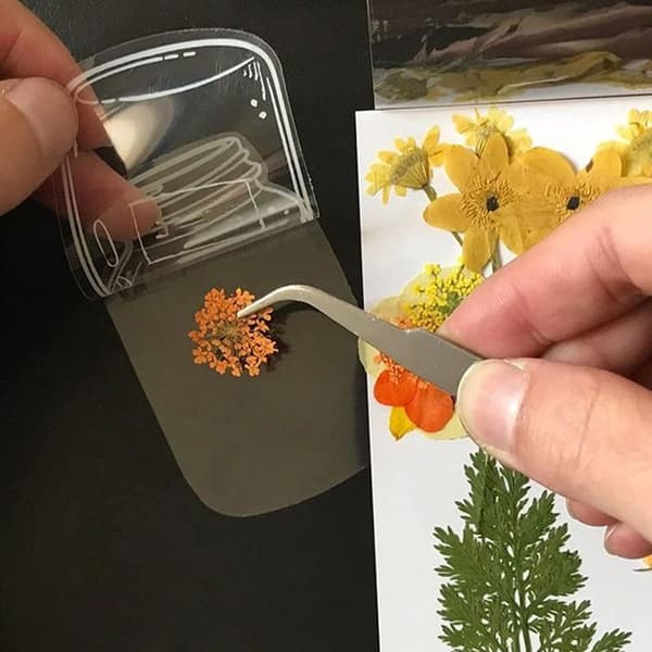 1 DIY-kit för bokmärken, inklusive hålslag och pincett.