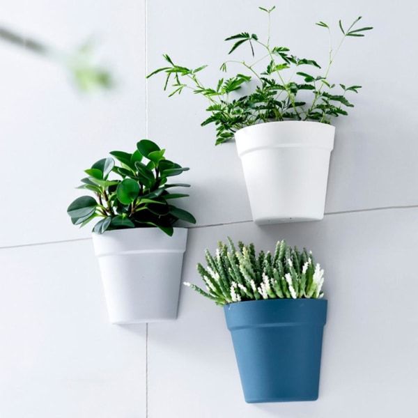 Vägghängda blomkrukor i plast utanför vit light grey