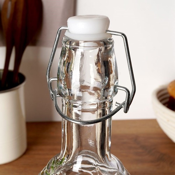 Vacker glasflaska med kork och klämma för drycker