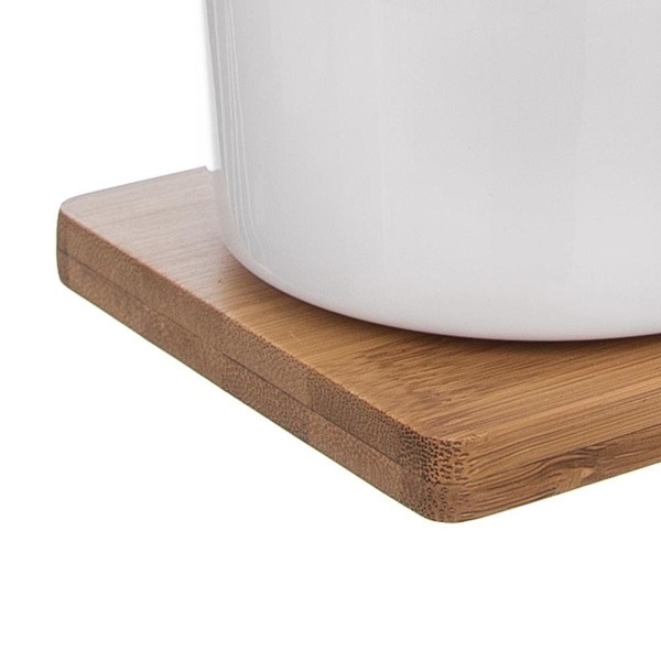 Elegant sukkerskål af porcelæn og flødekande på bambusbakke