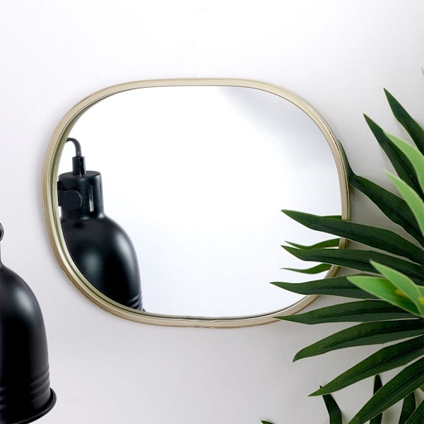 Soikea seinäpeili samppanjakultaisella kehyksellä - elegantti yksityiskohta