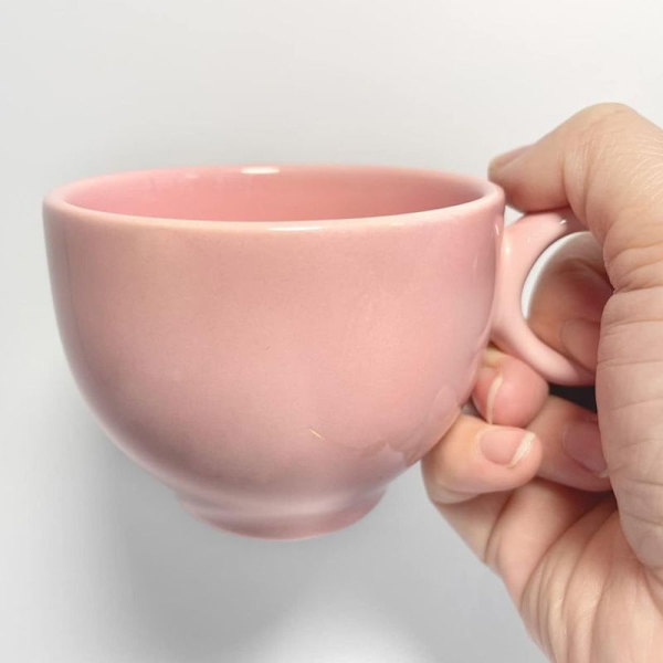 Rosa keramisk kaffekopp med matchende servise, blomst