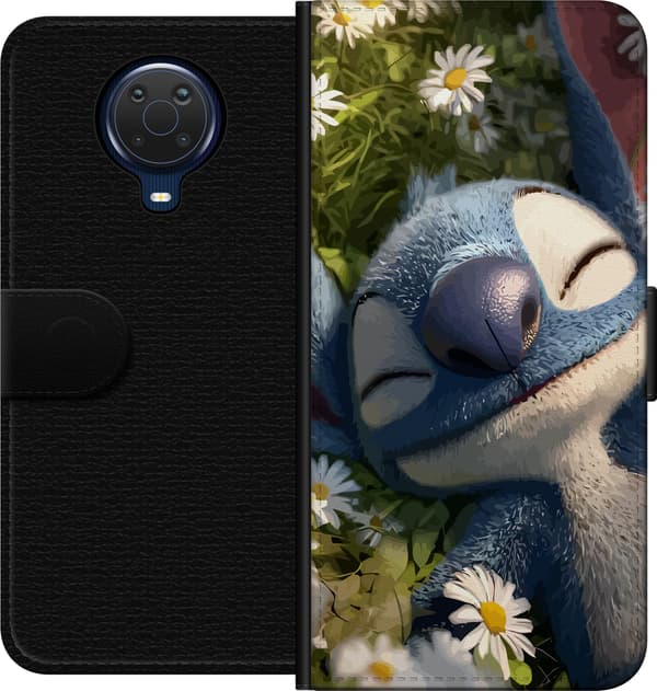 Kompatibel Tegnebogsetui til Nokia G20 Sovende blå rumfigur i nærbillede blandt små hvide margueritter og grønne planter blå