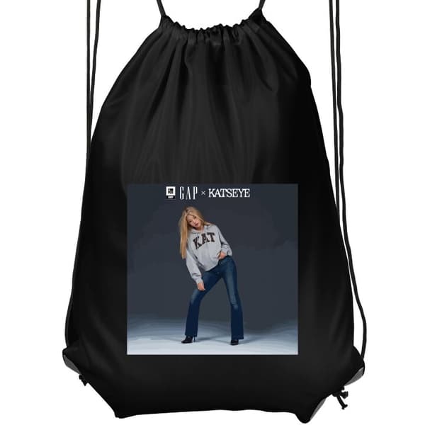 Gymnastikpose Sort KATSEYE blond medlem i grå trøje og blå jeans mod mørkegrå baggrund i moderne modefotografering sort Barn