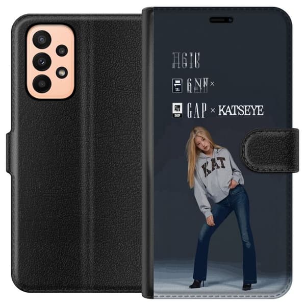 Kompatibel Tegnebogsetui til Samsung Galaxy A23 KATSEYE-blond medlem i grå trøje og blå jeans mod mørkegrå baggrund i moderne modefotografering grå