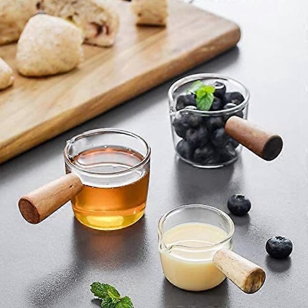 2 kpl läpinäkyvää lasia puukahvalla, kermakannu. 70 ml