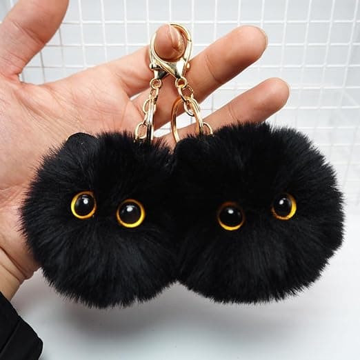 Sæt med 2 sorte kattenøgleringe, en perfekt gave til katteelskere, med søde plysrygsækcharms og fluffy pompon-nøgleringe.
