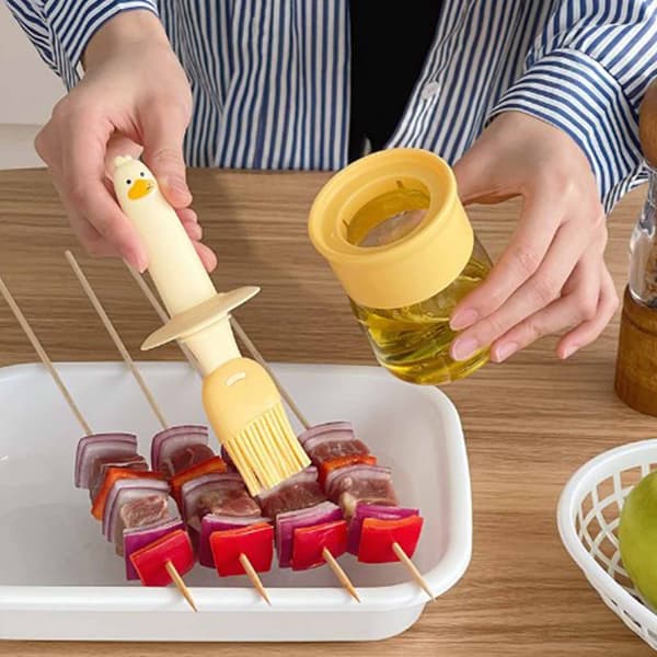 Orange oljedispenserflaska med silikonborste för köksbakning, matlagning och grillning