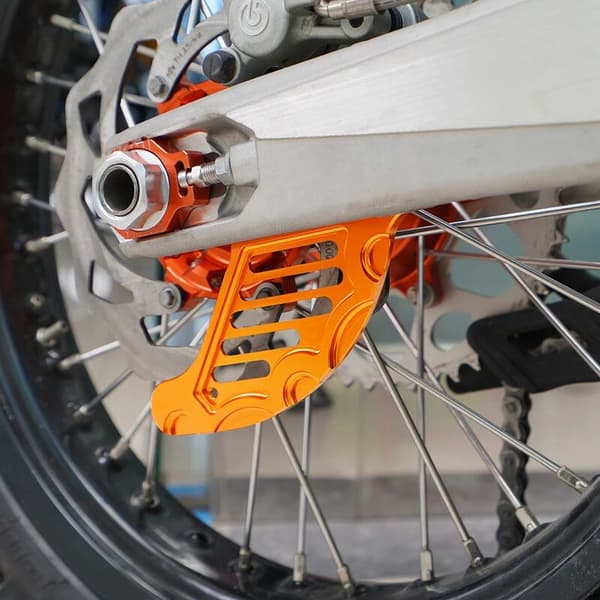 Lämplig för KTM 125 och andra 1-delade orange CNC-bakbromsskydd