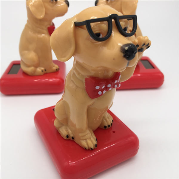 Solcells drivna kreativa gungande äppelpengar hund nickar på en gungbil tecknad