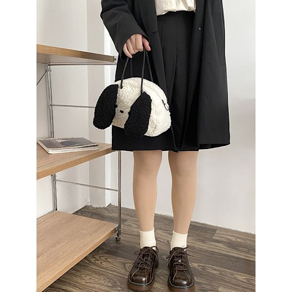 Kiharakarvainen koira, jolla on isot korvat, crossbody-reppu, söpö gi