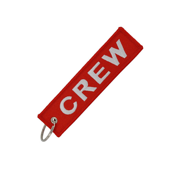 En CREW-nyckelbricka med broderad text i vitt på