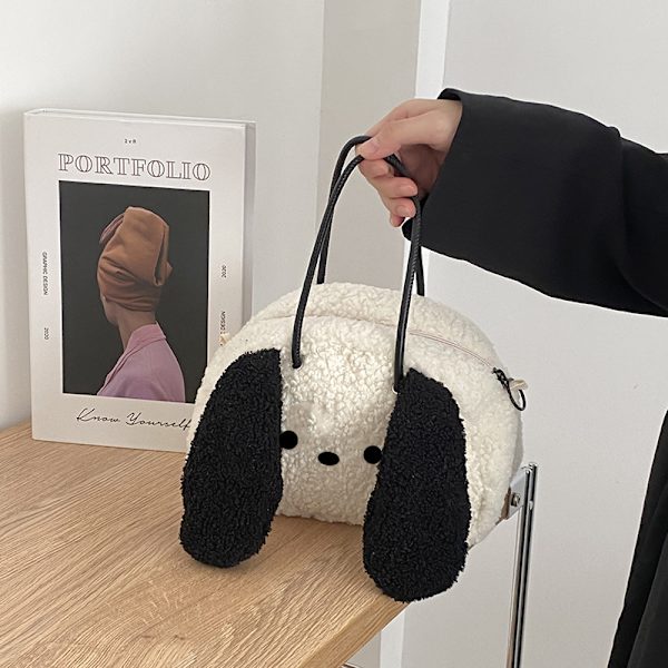 Kiharakarvainen koira, jolla on isot korvat, crossbody-reppu, söpö gi