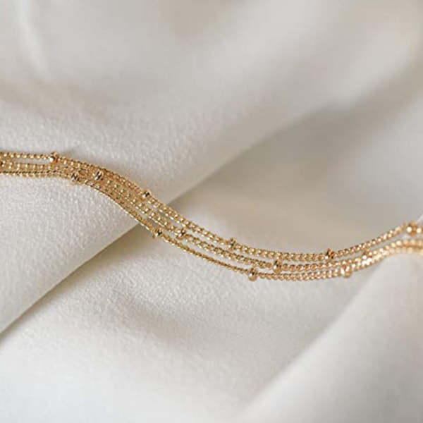 Guldjusterbart armband av laminerad rispärla i metall