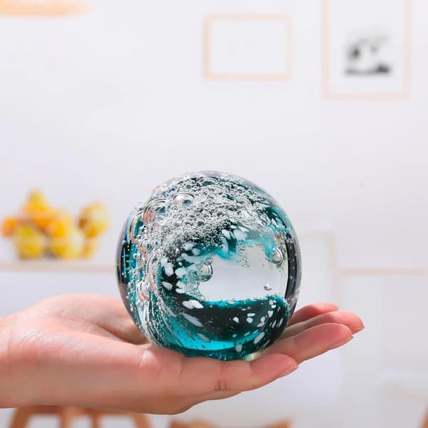 Handblåst glaskristallkula med vågdesign - ett dekorativt glassamlarobjekt.