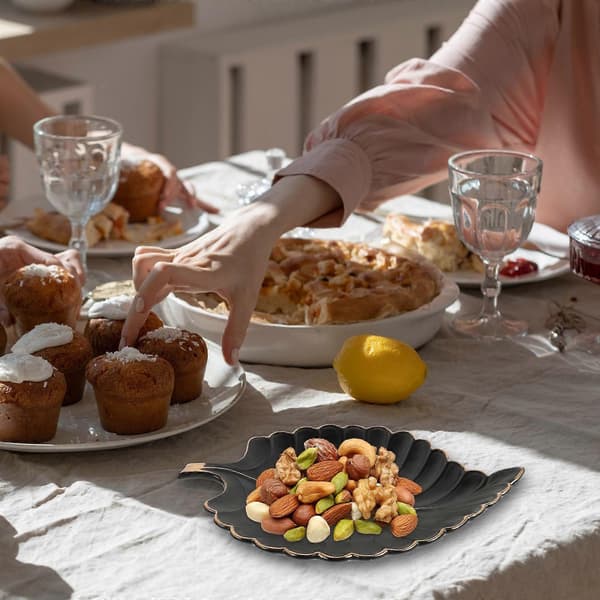 Elegant lövformad keramisk bricka med guldkant, lämplig för smycken och små prydnadssaker.