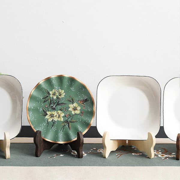 This handmade, foldable wooden stand features a curved design and is suitable for displaying saucers, tea sets, and other home decor. Ebony M