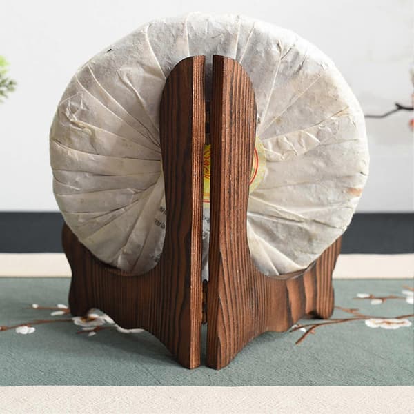 This handmade, foldable wooden stand features a curved design and is suitable for displaying saucers, tea sets, and other home decor. Ebony S