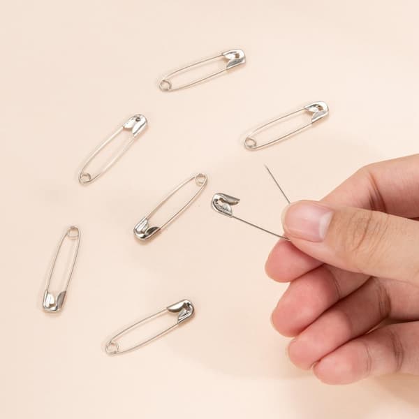 100 platinagull sikkerhetsnåler, som måler 31 x 6,5 x 1,5 mm.