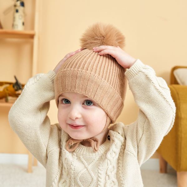 Stickad barnhatt i enfärgad färg med flätad öronvärmare plus
