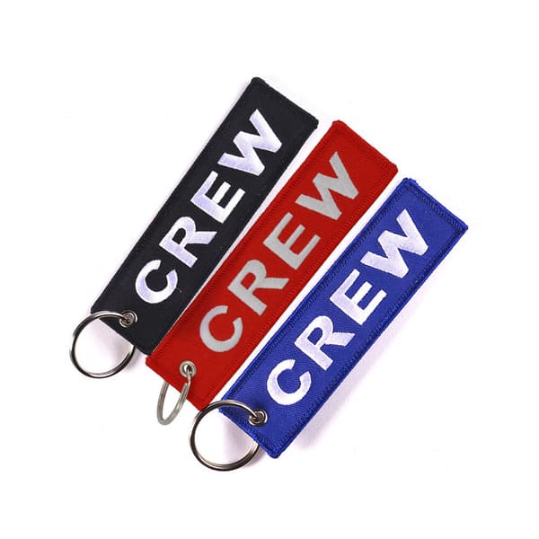CREW-tietokoneen ompelun avaimenperä valkoisilla kirjaimilla sinisellä
