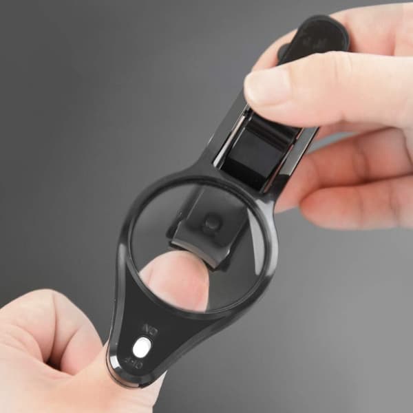 Negleklipper med sammenleggbart forstørrelsesglass og LED-lys, finger