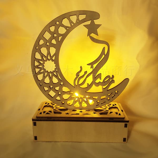LED-lys i tre med utskårne bokstaver og måne for islamsk Eid Mubarak Rama