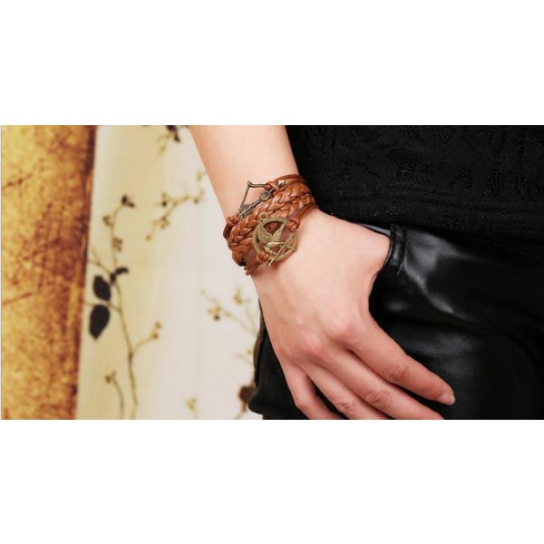 Brunt läderarmband med en pilbåge och en fågel