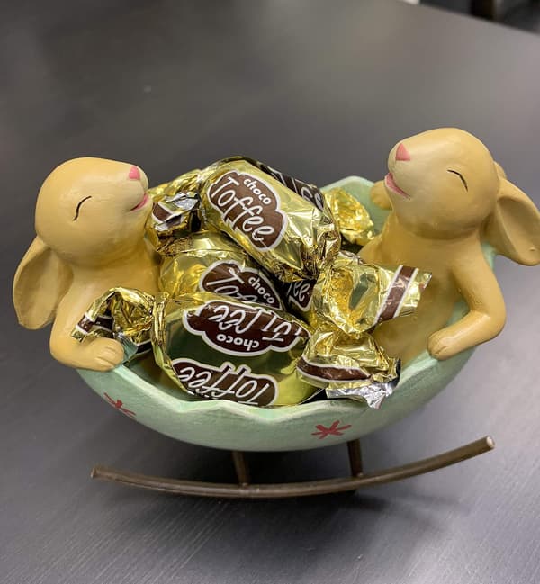 Grinende kaniner, der vugger i en påskeæggevugge, forårs-påske