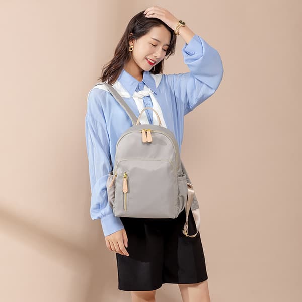 Light Grey Water-Resistant Nylon Backpack with Gold-Tone Zippers Faux Leather Top Handle Multiple Zippered Compartments and Side Pockets