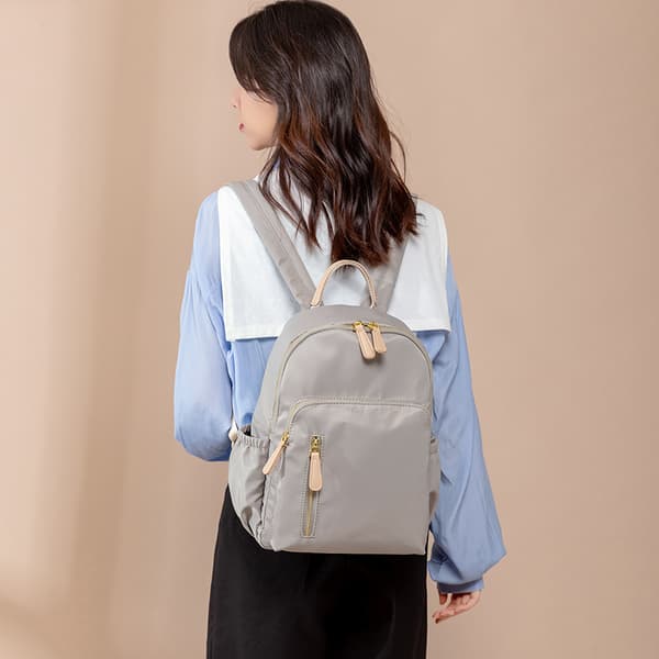 Light Grey Water-Resistant Nylon Backpack with Gold-Tone Zippers Faux Leather Top Handle Multiple Zippered Compartments and Side Pockets