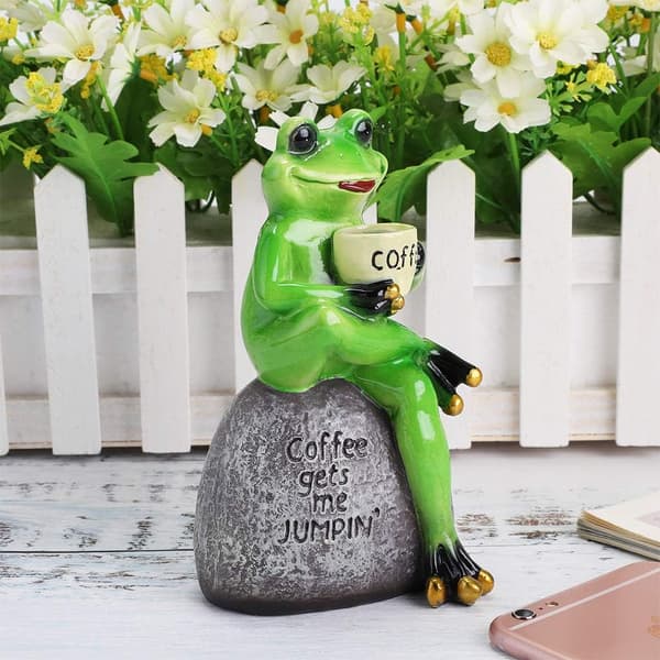 Harpiksfrøfigur, der sidder på stenstatue, sød, kreativ og sjov