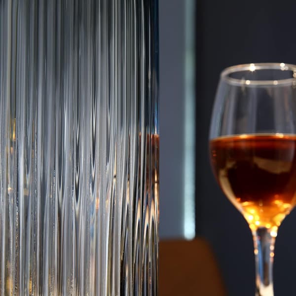 Liten cylindrisk vas i grått räfflat glas för rustik matbordsdekoration