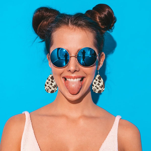 Kollektion av fashionörhängen i konstläder med komönster - Retro ko djurhud päls tjurfläck