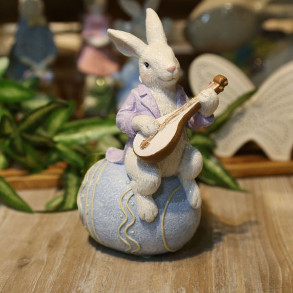 1 Europeisk-inspirert påskehare i resin med paljetter, spiller lutt og sitter på egg