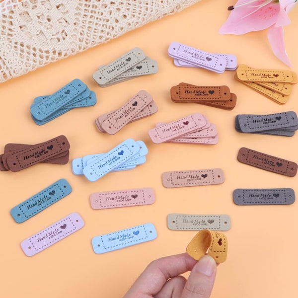 Pakke med 100 håndlavede tøjlabels, personlige læderlabels, håndlavede sylabels med huller til strikning (10 farver, 56 x 15mm)