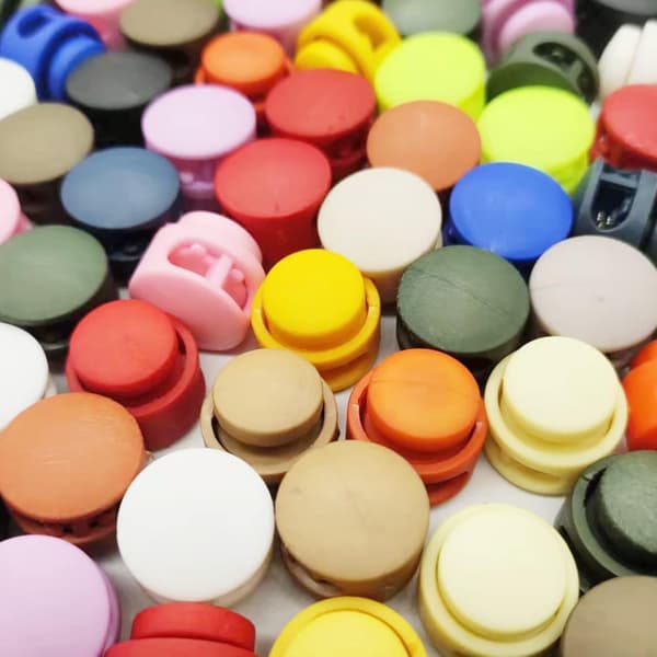 50-pak plastikfjeder-snorelåse med dobbelthuller til snore (tilfældig farve)