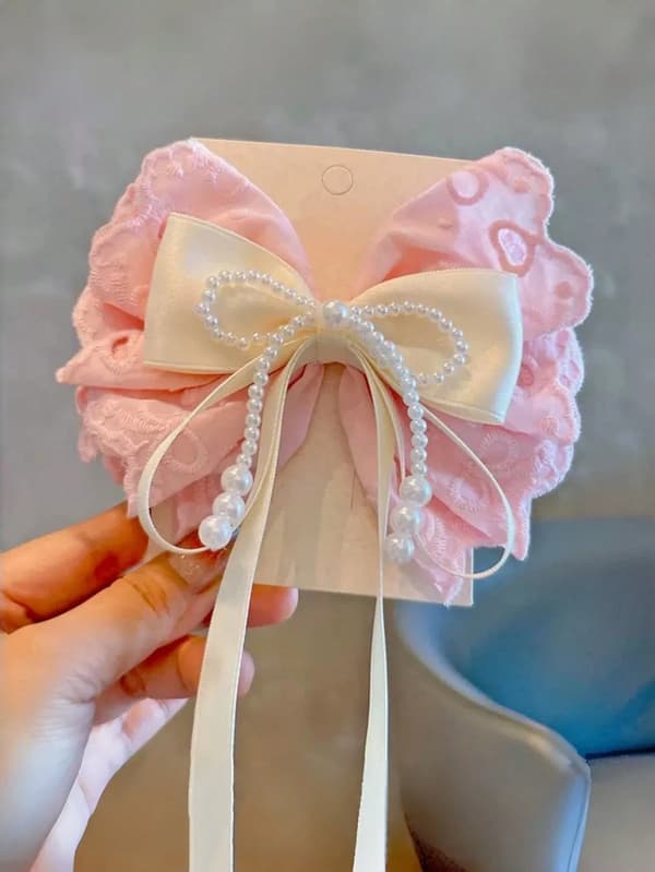 Pigehårklemme med sløjfe, blonde og perledetaljer Pink