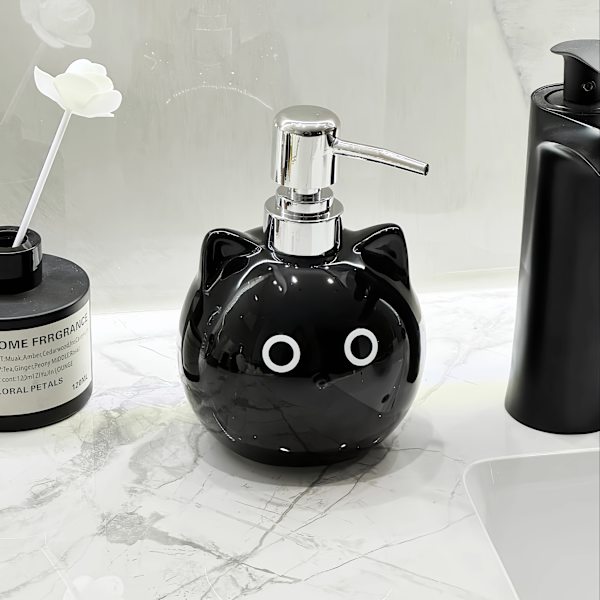 Keraamisessa lotion-pullossa on pyöreäsilmäinen musta kissa -design. black