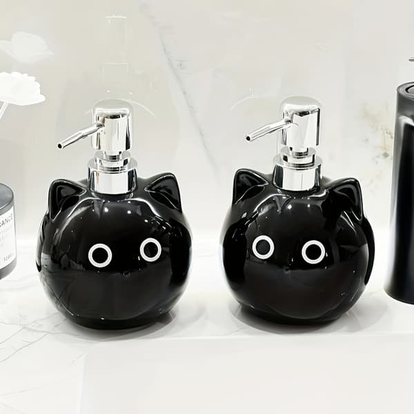 Keraamisessa lotion-pullossa on pyöreäsilmäinen musta kissa -design. black